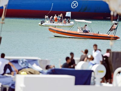 Quelques personnes viennent soutenir les migrants bloqués sur le Diciotti, bateau des garde-côtes italiens, le 23 août 2018 - Giovanni ISOLINO [AFP]
