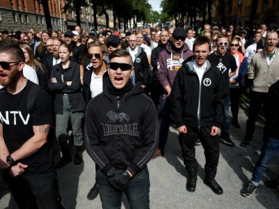 Des militants du mouvement néonazi suédois NMR crient des slogans lors d'une manifestation à Stockholm le 25 août 2018 - Fredrik Persson [TT News Agency/AFP]