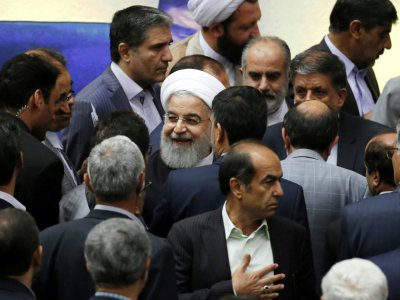 Le président iranien Hassan Rohani entouré de députés lors de son audition devant le Parlement à Téhéran, le 28 août 2018 - ATTA KENARE [AFP]