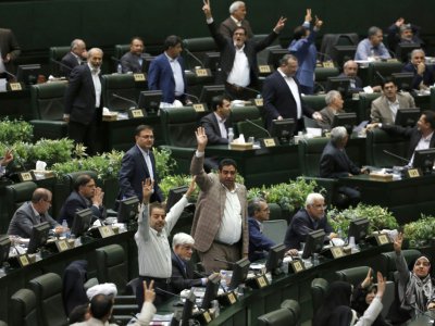 Des députés iraniens se lèvent alors que le président iranien Hassan Rohani s'exprime devant le Parlement à Téhéran, le 28 août 2018 - ATTA KENARE [AFP]