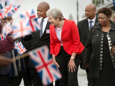 La Première ministre britannique Theresa May est entourée de petits Sud-Africains lors d'une visite d'une école du Cap, le 28 août 12018 dans le township de Gugulethu, au Cap. - Rodger BOSCH [POOL/AFP]