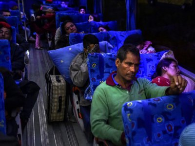 Joel Mendoza et Edicth Landinez traversent le frontière entre l'Equateur et le Pérou dans un bus humanitaire, le 24 août 2018 - Luis ROBAYO [AFP]