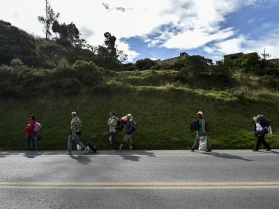 Les familles vénézuéliennes Mendoza Landinez et Lomelly marchent le long de l'autoroute panaméricaine en Colombie pour rejoindre le Pérou, le 23 août 2018 - Luis ROBAYO [AFP]