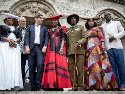 Le sénateur de Berlin Dirk Behrendt (3e à gauche) pose avec Esther Utjiua Muinjangue (à gauche), présidente de la  Fondation Ova Herero Genocide avec d'autres membres de la délégation de Namibie à Berlin le 27 août 2018 - Kay Nietfeld [dpa/AFP]