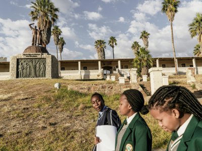Des écolières de Namibie passent le 20 juin 2017 devant un monument à la mémoire des victimes du génocide contre les Herero et les Nama en 1904 - GIANLUIGI GUERCIA [AFP/Archives]