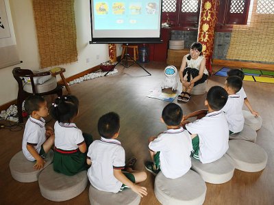 L'éducatrice Candy Xiong présente le robot Keeko dans une maternelle chinoise, le 30 juillet 2018 - GREG BAKER [AFP]