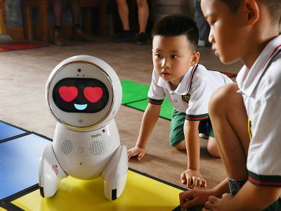 Des enfants de l'école maternelle Yiswind en Chine découvrent le robot Keeko, le 30 juillet 2018 - GREG BAKER [AFP]