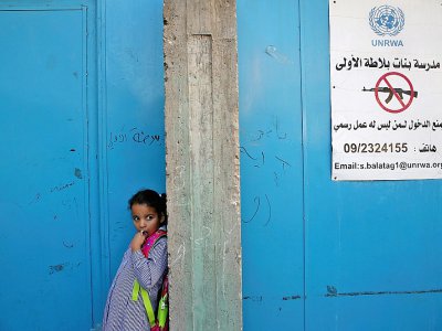 Une élève se tient devant l'entrée d'une école gérée par l'Agence de l'ONU pour les réfugiés (Unrwa) dans le camp de  Balata, à l'est de Naplouse, en Cisjordanie occupée, le 29 août 2018 - Jaafar ASHTIYEH [AFP]