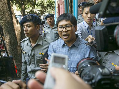 Le journaliste birman Wa Lone (c) escorté par des policiers après son procès à Rangoun, le 4 avril 2018 - SAI AUNG MAIN [AFP/Archives]