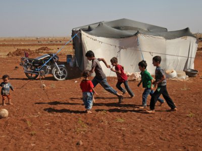 Des enfants syriens jouent à la balle devant une tente dans un camp de déplacés près du village de Surman dans la province d'Idleb en Syrie, le 5 septembre 2018 - Amer ALHAMWE [AFP]