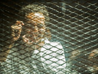 Le photojournaliste égyptien Mahmoud Abu Zeid "Shawkan" dans le box des accusés dans un tribunal du Caire le 8 septembre 2018 - Mohamed el-Shahed [AFP]