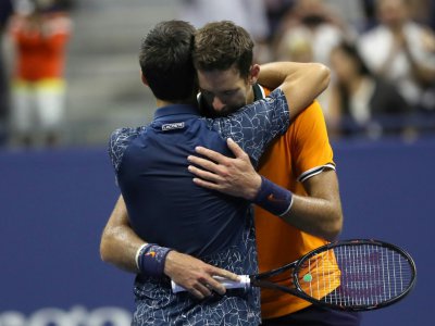 Novak Djokovic (g), vainqueur de l'US Open, dans les bras de son adversaire Juan Martin del Potro (d), dimanche 9 septembre 2018 à New York. - Eduardo MUNOZ ALVAREZ [AFP]