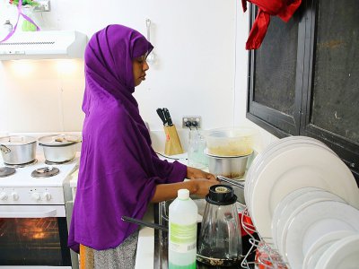 Une réfugiée de Somalie qui a tenté plusieurs fois de se suicider effectue des tâches ménagères dans une cuisine du camp numéro 5 sur l'île de Nauru, le 2 septembre 2018 - Mike LEYRAL [AFP]