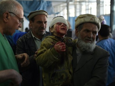 Un Afghan porte un enfant blessé dans l'explosion d'une voiture piégée devant l'ancien ministère de l'Intérieur à Kaboul le 27 janvier 2018. - WAKIL KOHSAR [AFP/Archives]