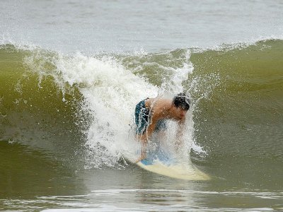 Un surfeur à Myrtle Beach, en Caroline du Sud, le 13 septembre 2018 à quelques heures de l'arrivée de l'ouragan Florence - Alex Edelman [AFP]