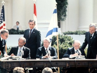 Anouar al-Sadate (à gauche) et Menachem Begin (à droite) signent le traité de Washington en présence de Jimmy Carter (au centre) le 26 mars 1979 - - [FILES-CONSOLIDATED NEWS PICTURES/AFP]