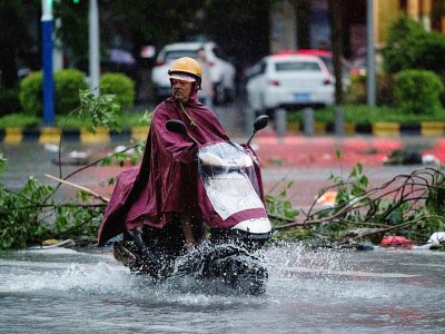 Un homme à moto dans une rue inondée après le passage du typhon Mangkhut, le 17 septembre 2018 à Yangjiang, dans la province chinoise du Guangdong - NICOLAS ASFOURI [AFP]