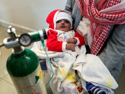 Un Yéménite porte un bébé malade dans les locaux du ministère de la Santé à Sanaa, en attente d'une évacuation pour recevoir des soins à l'étranger, le 18 septembre 2018 - [AFP]