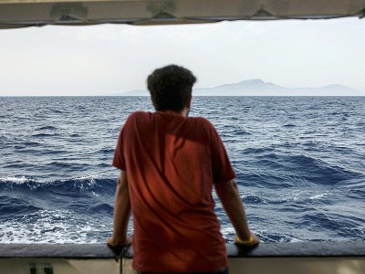 Un migrant scrute la mer depuis le pont d'un bateau de l'ONG espagnole Proactiva Open Arms, le 1er juillet 2018 - Olmo Calvo [AFP/Archives]