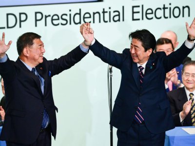 Le Premier ministre japonais Shinzo Abe (D) après sa réélection à la tête de son Parti libéral-démocrate, aux côtés de son rival Shigeru Ishiba, à Tokyo le 20 septembre 2018 - Martin BUREAU [AFP]