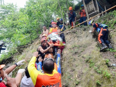 Des sauveteurs évacuent un blessé après un glissement de terrain, le 20 septembre 2018 dans le village de Tina-an, sur l'île philippine de Cebu - ALAN TANGCAWAN [AFP]