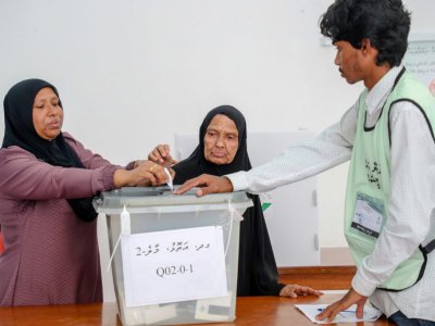 Une femme aide sa mère âgée à voter dans un bureau de Malé, le 23 septembre 2018 aux Maldives - - [AFP]