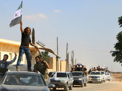 Des combattants rebelles syriens, du Front national de libération (FNL) récemment créé, défilent dans le nord de la province syrienne d'Idleb, après un entraînement militaire, le 11 septembre 2018 - Aaref WATAD [AFP/Archives]