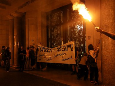 Des militants indépendantistes catalans accrochent une banderole sur un bâtiment public de Barcelone lundi 1er octobre, premier anniversaire du référendum sur l'indépendance de la Catalogne - PAU BARRENA [AFP]