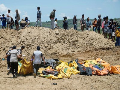 Des corps sont transportés dans une fosse commune avant une cérémonie funéraire pour les victimes du séisme à Palu sur l'île des Célèbes en Indonésie, le 1er octobre 2018 - BAY ISMOYO [AFP]