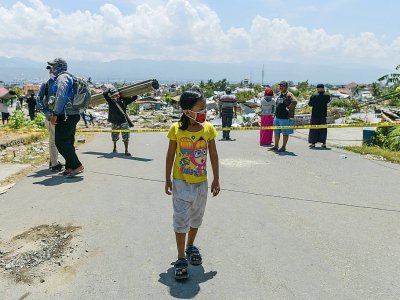 Une jeune fille porte un masque au milieu des décombres dans le village de Perumnas Balaroa, sur l'île des Célèbes le 2 octobre 2018. - Mohd RASFAN [AFP]