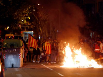 Des manifestants indépendantistes devant un feu allumé dans une rue de Barcelone le 1er octobre 2018 - Pau Barrena [AFP]