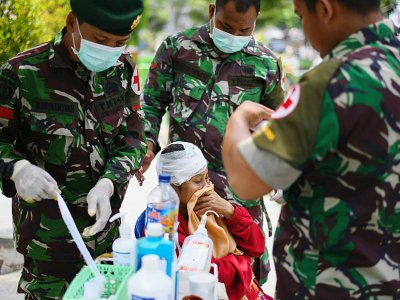 Des médecins militaires soignent une femme blessée dans un camp à Palu, le 4 octobre 2018 en Indonésie - JEWEL SAMAD [AFP]