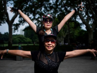 Deux femmes en train de danser dans un parc de Shanghai, le 2 septembre 2018 - Johannes EISELE [AFP]