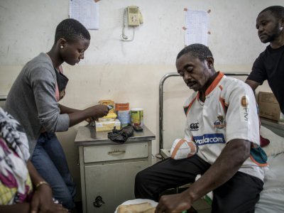 Beckley Motome reçoit l'aide de sa famille pour manger sur son lit d'hôpital de Buea, le 4 octobre 2018 - MARCO LONGARI [AFP]