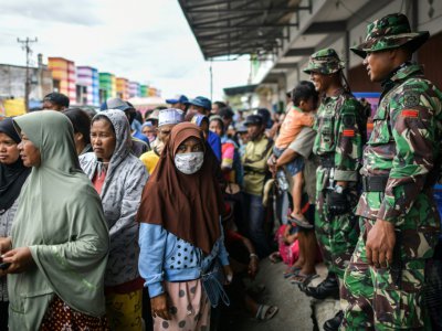 Des habitants de Palu, aux Célèbes, font la queue le 7 octobre 2018 pour recevoir de l'aide après le séisme suivi d'un tsunami qui a ravagé l'île. - MOHD RASFAN [AFP]