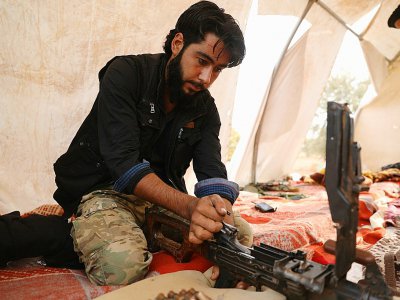 Un combattant rebelle syrien du Front national de libération (FNL) s'occupe de son arme, dans le sud-est de la province d'Idleb, le 9 octobre 2018 - OMAR HAJ KADOUR [AFP]