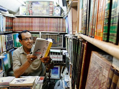 Un Irakien lit un livre chez un bouquiniste de Najaf en Irak, le 16 août 2018 - Haidar HAMDANI [AFP]