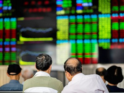 Des investisseurs surveillent le cours des actions à Shangai, en Chine, le 25 septembre 2018 - Johannes EISELE [AFP/Archives]