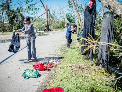 Une famille accroche des vêtements à des arbres afin de les faire sêcher, après le passage de l'ouragan Michael, le 11 octobre 2018 à Panama City (Floride). - Emily KASK [AFP]