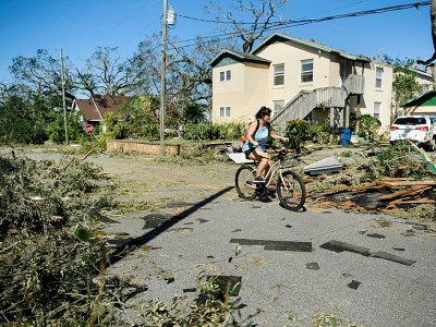 Une femme à vélo dans les rues de Panama city (Floride), après le passage de l'ouragan Michael le 11 octobre 2018. - Brendan Smialowski [AFP]