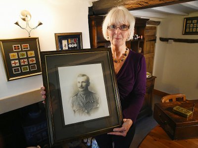Melanie Henwood pose avec le portrait de son arrière grand-père Enoch Davis, combattant de la Première Guerre mondiale, dans son domicile de Hartwell en Angleterre, le 10 octobre 2018. - PAUL ELLIS [AFP]