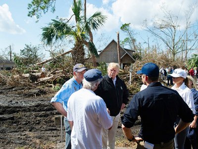 Le président américain, au centre, avec sa femme Melania Trump, casquette USA sur la tête, sont en Floride le 15 octobre 2018, cinq jours après le passage de l'ouragan dévastateur Michael - SAUL LOEB [AFP]