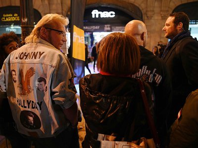 Des fans font la queue en attendant la mise en vente à minuit de l'album posthume de Johnny Hallyday à la FNAC des Champs-Elysées à Paris, le 19 octobre 2018 - CHRISTOPHE ARCHAMBAULT [AFP]