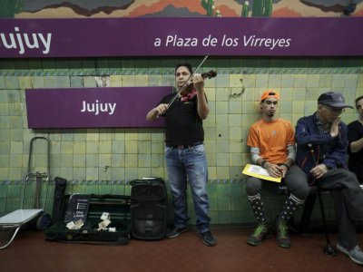 Parmi les musiciens exilés, beaucoup jouent dans les stations de métro de la capitale argentine - EITAN ABRAMOVICH [AFP]