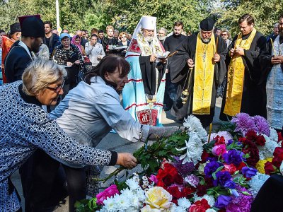Des gens déposent des fleurs à Kertch lors d'une cérémonie d'hommages à la tuerie du lycée polytechnique, le 18 octobre 2018 - Andrey PETRENKO [AFP]
