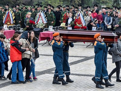 Des secouristes du ministère russe des situations d'urgence portent le cercueil d'une victime de la fusillade dans un lycée, lors d'une cérémonie funéraire à Kertch, en Crimée, le 19 octobre 2018 - Andrey PETRENKO [AFP]