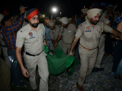 Des policiers transportent le corps d'une victime après un accident de train, le 19 octobre 2018 à Amritsar, en Inde - NARINDER NANU [AFP]