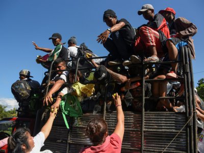 Honduran migrants traveling on a truck towards the US border receive food donations in the Mexican town of Acacoyagua, in Chiapas state - Johan ORDONEZ [AFP]