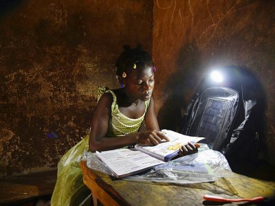 Amondji Anin Lucienne étudie à la lumière de son cartable, le 17 septembre 2018 - Sia KAMBOU [AFP]