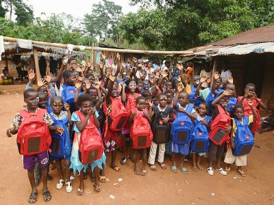 Des écoliers montrent leurs cartables solaires, le 16 septembre 2018 à Rubino, en Côte d'Ivoire - Sia KAMBOU [AFP]